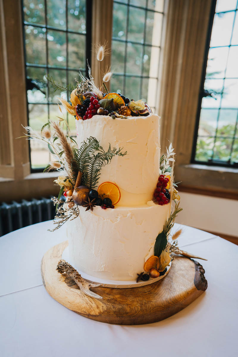a two tiered wedding cake with autumnal decorations