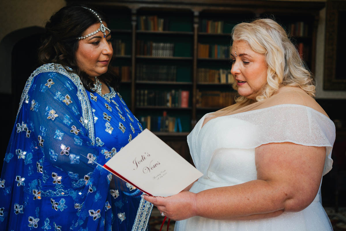 a bride reads her vows to her wife-to-be during their same sex wedding at Thornbury Castle
