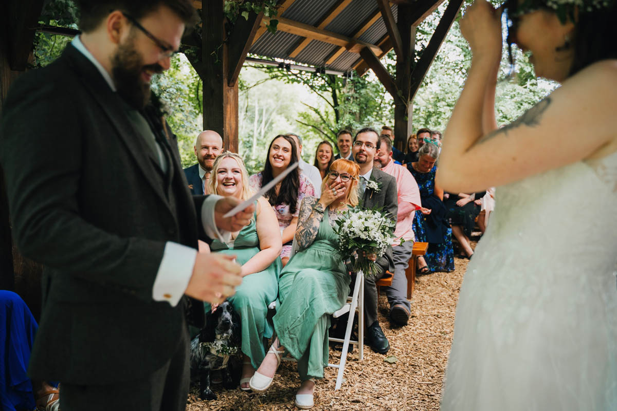 wedding guests laugh at the groom's vows