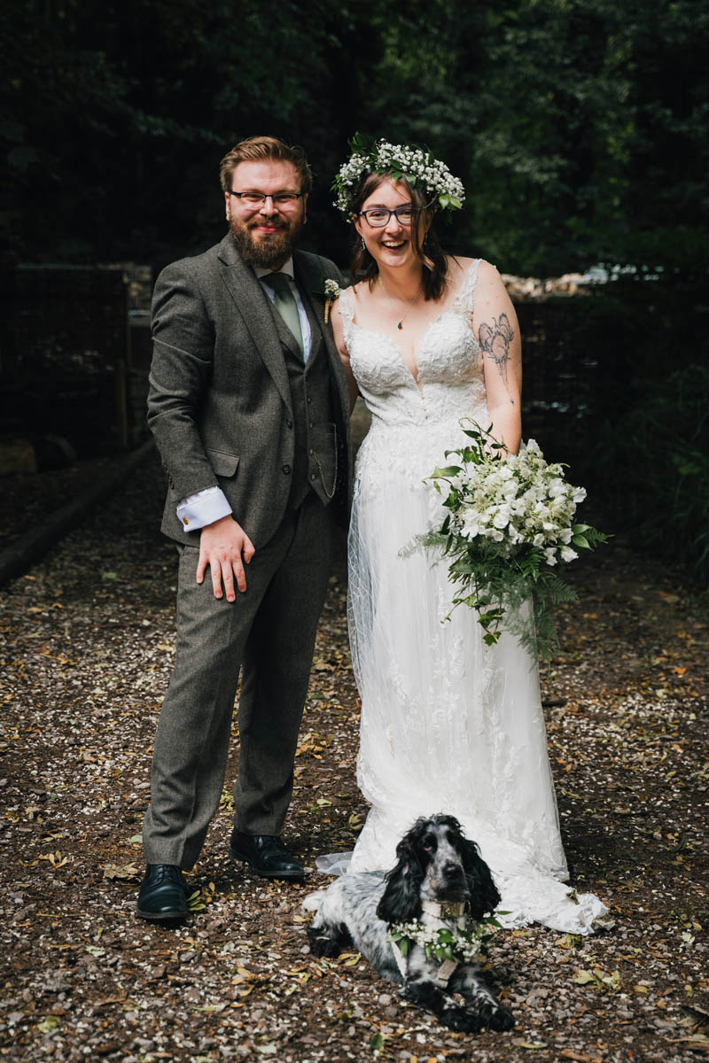 the bride and her new husband along with their cocker spaniel dog and a wedding bouquet