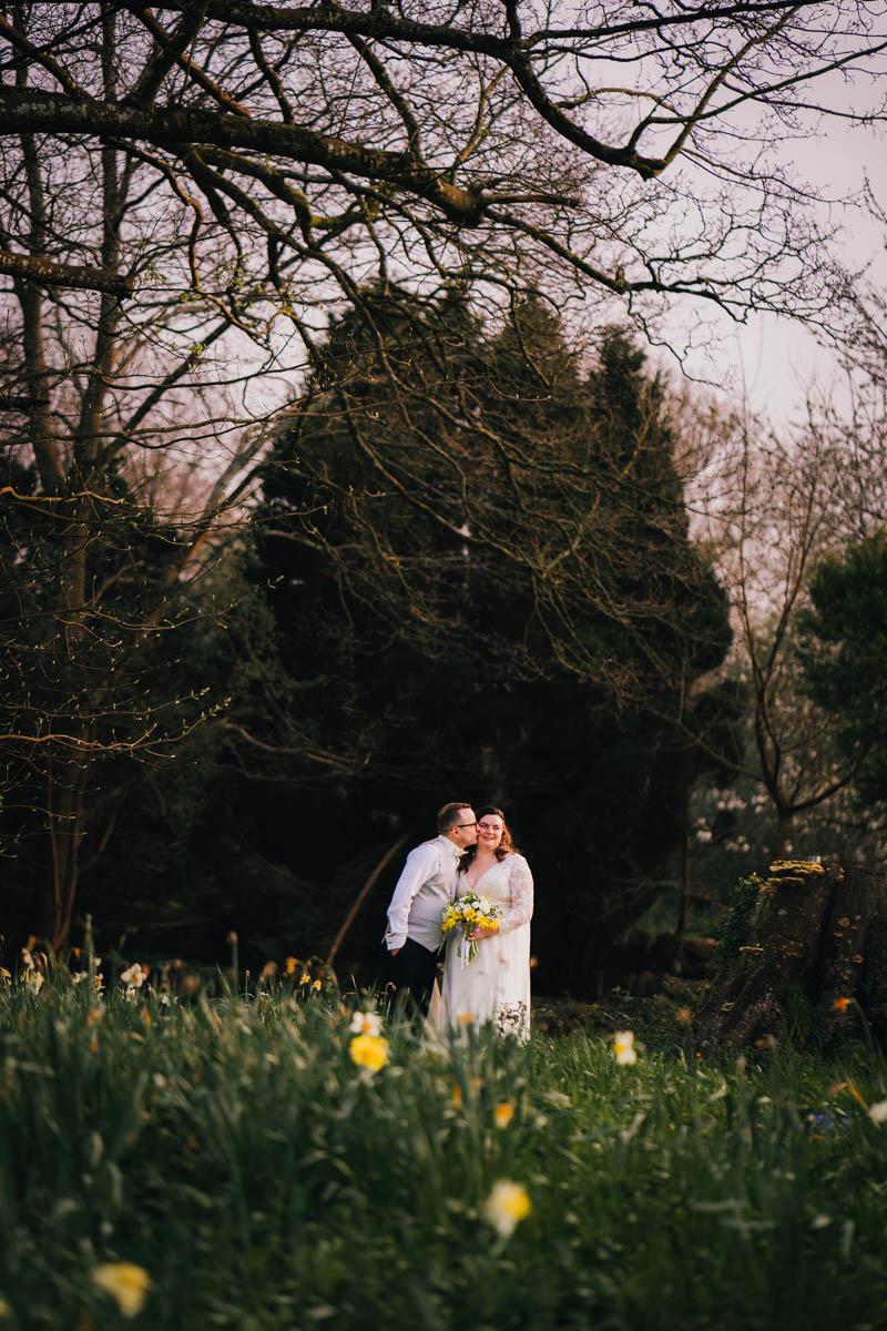 a couple share a kiss in the grounds of Coombe Lodge