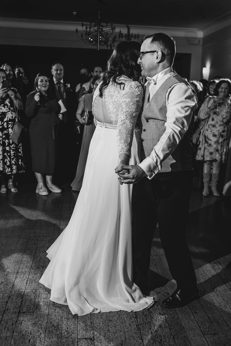 black and white portrait shot of the bride and groom sharing their first dance