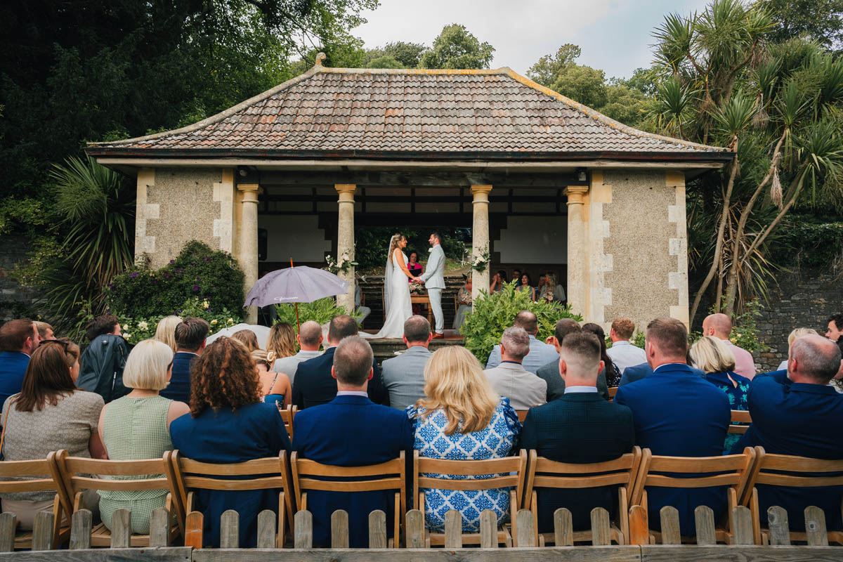 wedding guests watch the ceremony under the summer house at barley wood