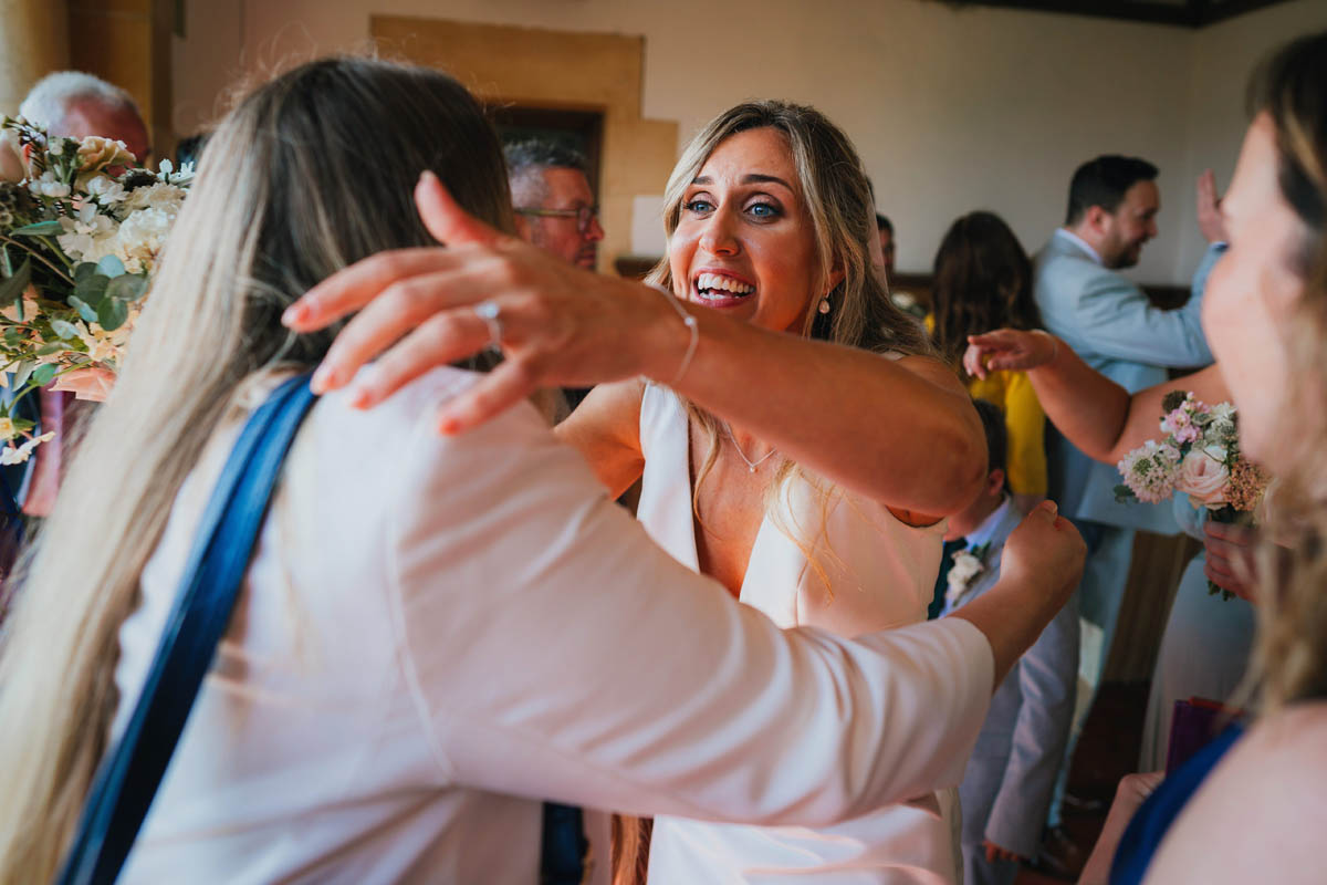the bride hugs a wedding guests excitedly