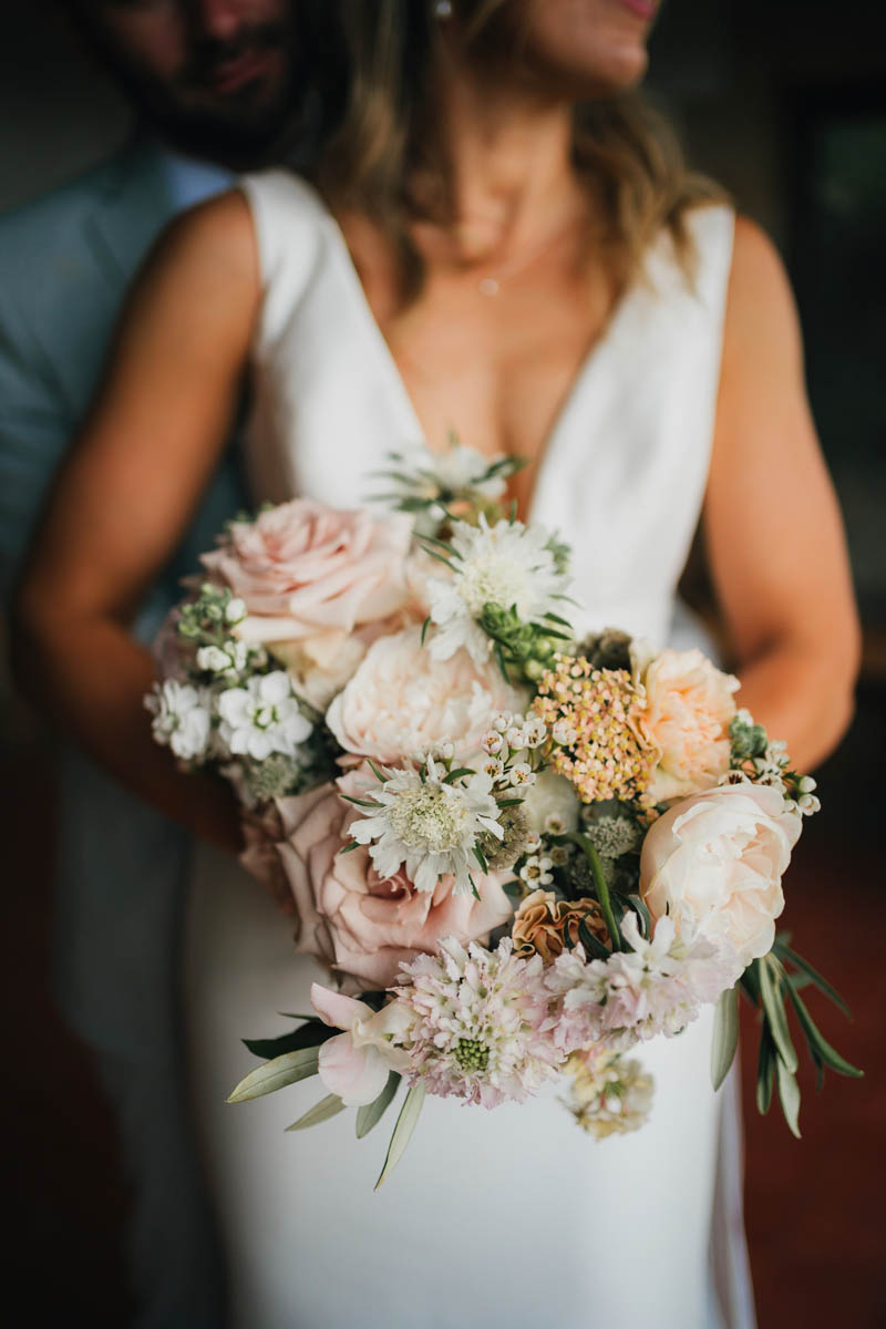 the bridal bouquet with bride behind and out of focus