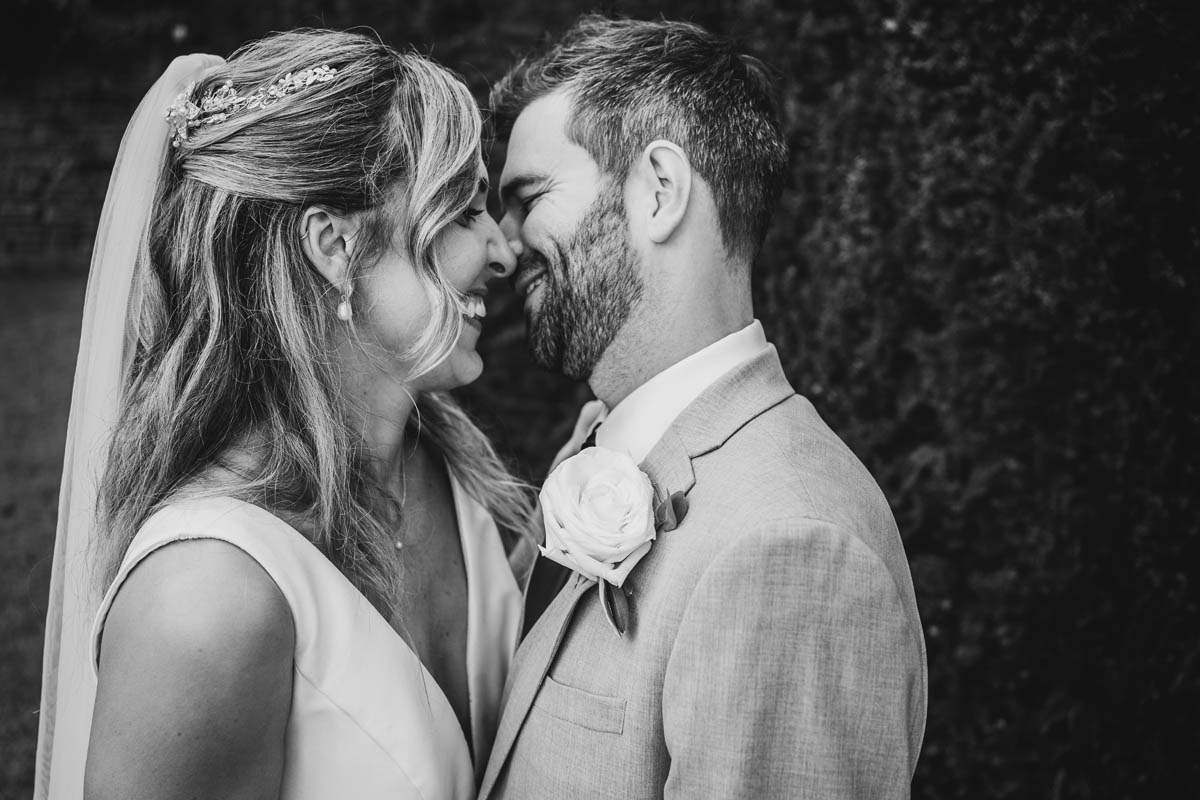 black and white portrait of the groom kissing his wife