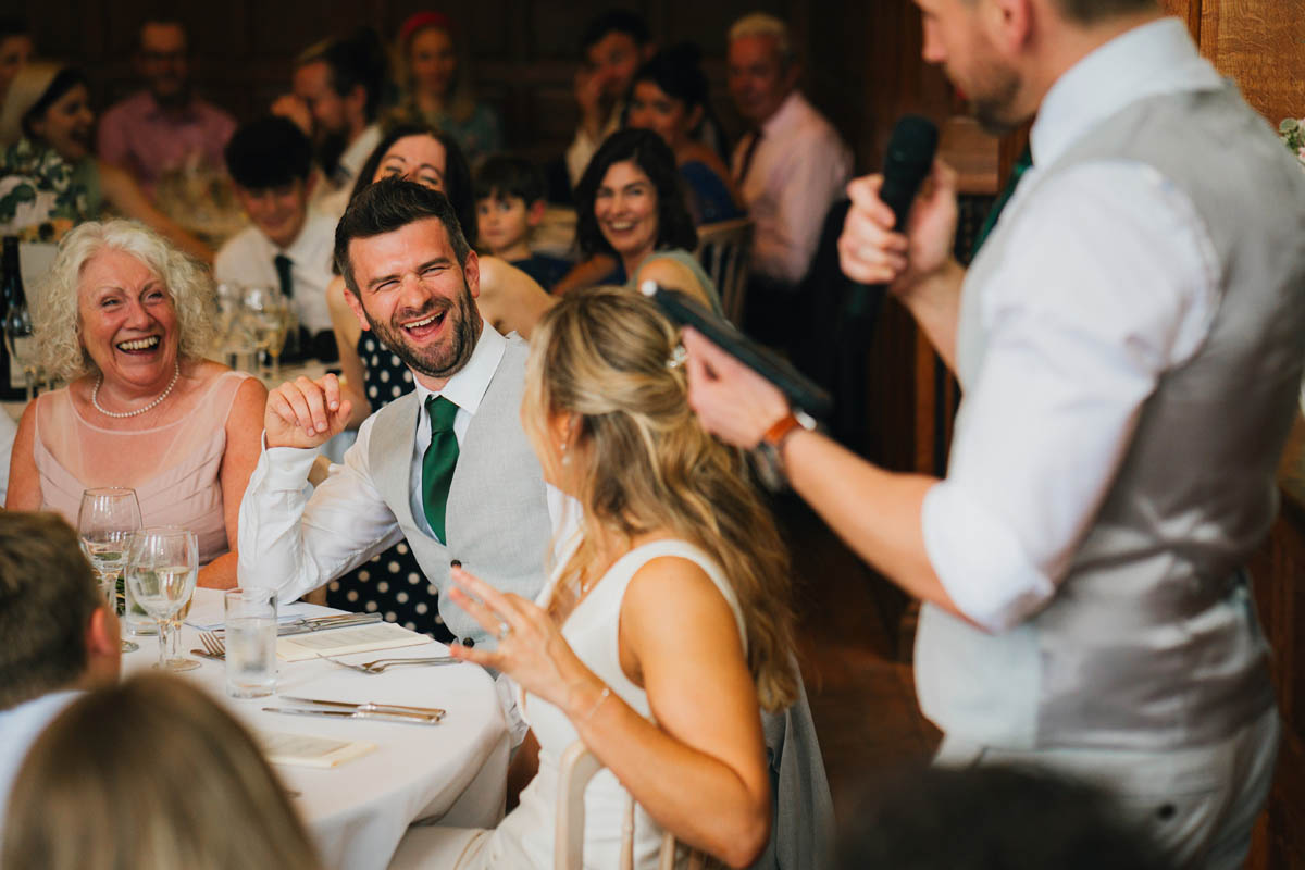 the wedding guests laugh at the best man's speech