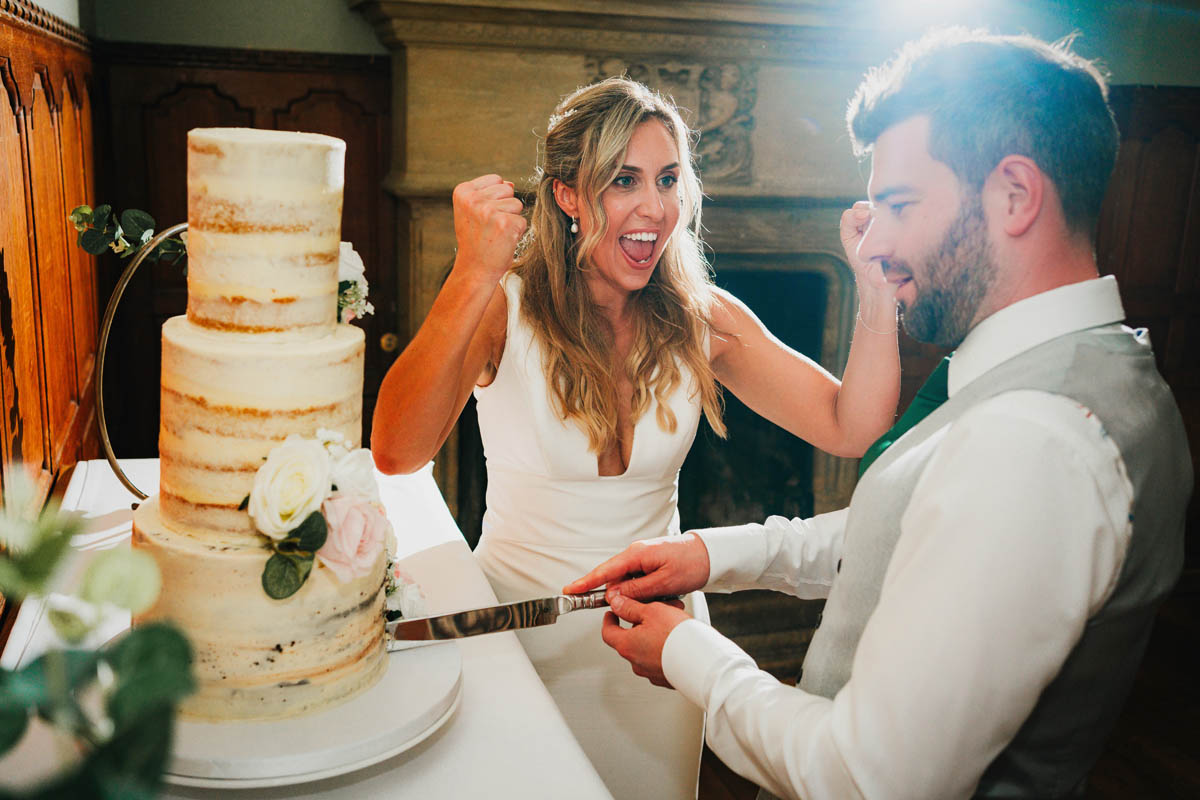 the bride exclaims as her new husband cuts the three tiered wedding cake