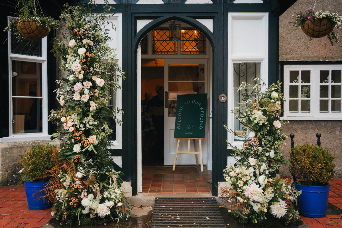 a large floral arrangement for a wedding outside the front door of Barley wood house