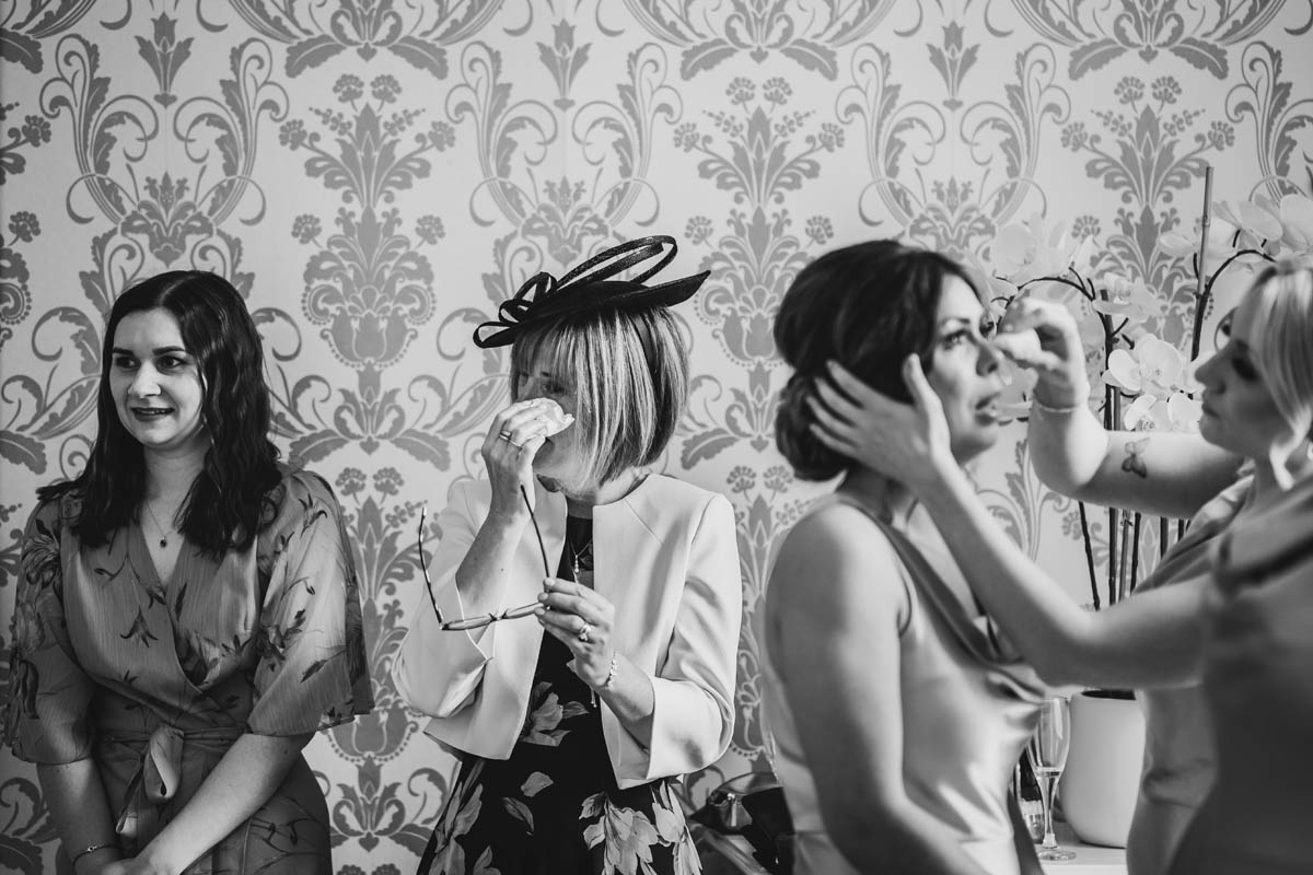 bridesmaids and the mother of the bride wipe away tears
