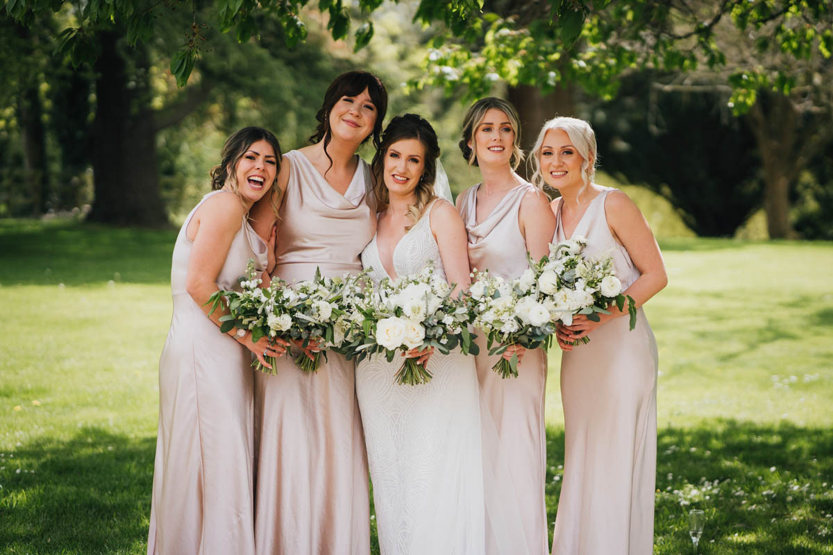 the bride and her bridesmaids all hold their bouquets and pose for the camera