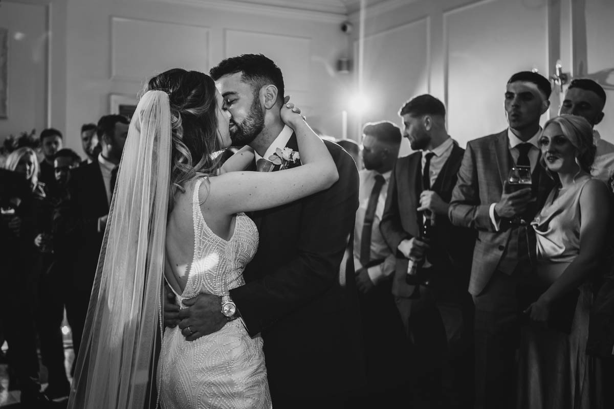 the bride and groom sharing their first dance, in black and white
