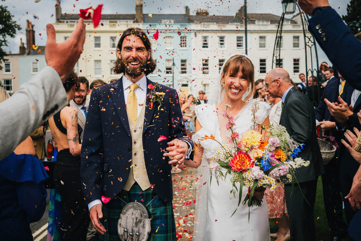wedding guests throw confetti over the new mr and mrs