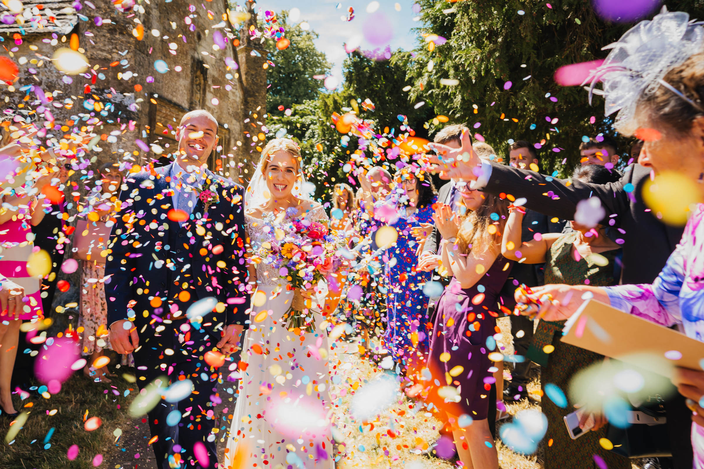 A showering of confetti over the bride and groom has they leave their Herefordshire church wedding ceremony