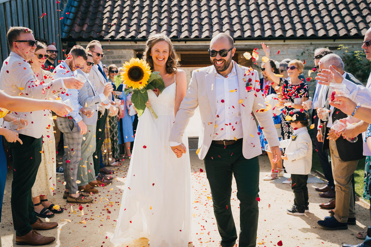 guests throw confetti over the newly-weds