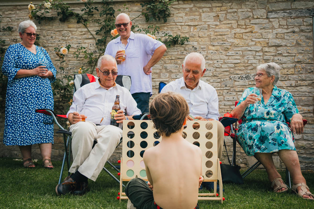 a child plays connect four with 5 older adults