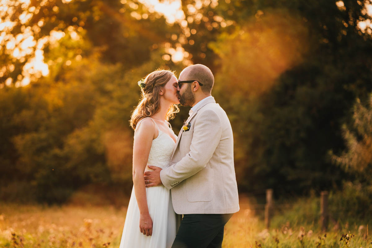 a bride and groom kiss at golden hour