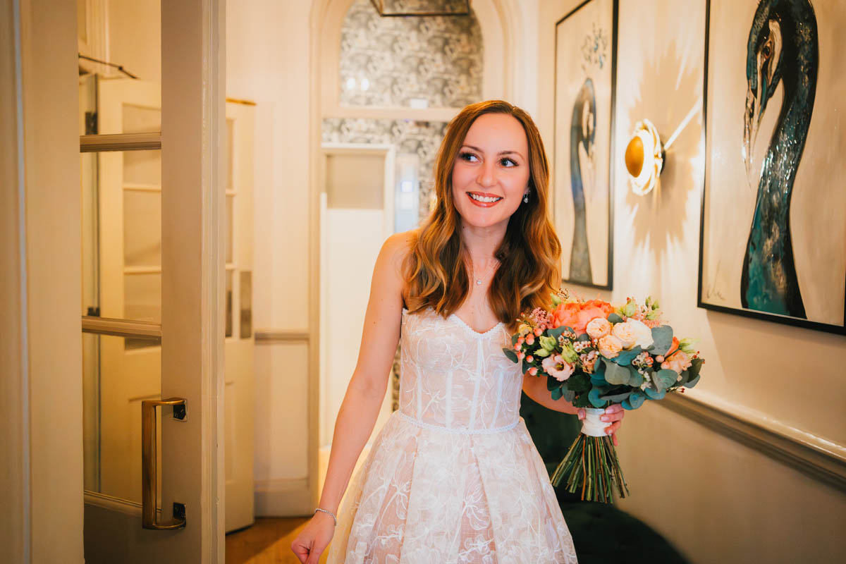 the bride smiling and holding her wedding bouquet