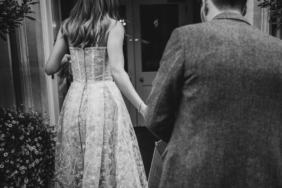 black and white image of the bride leading her groom into the wedding venue