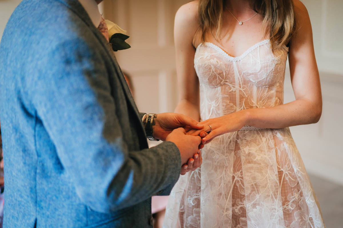 the groom slips the wedding ring onto his wife's finger