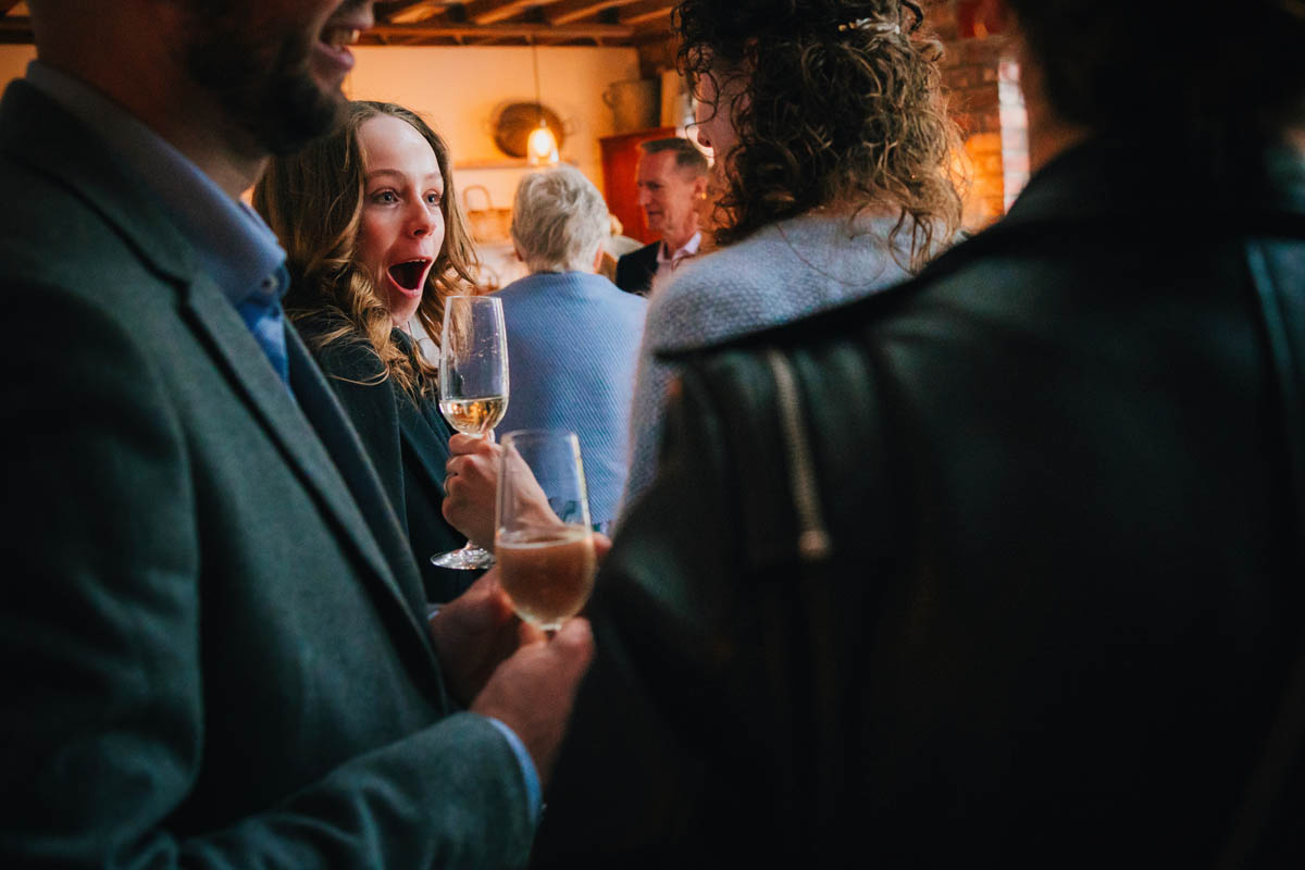 a bridesmaid looks surprised whilst drinking champagne