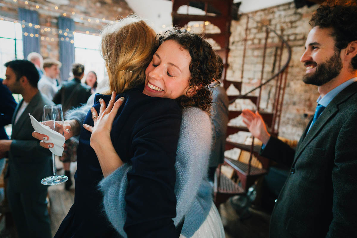 wedding guests hug the bride