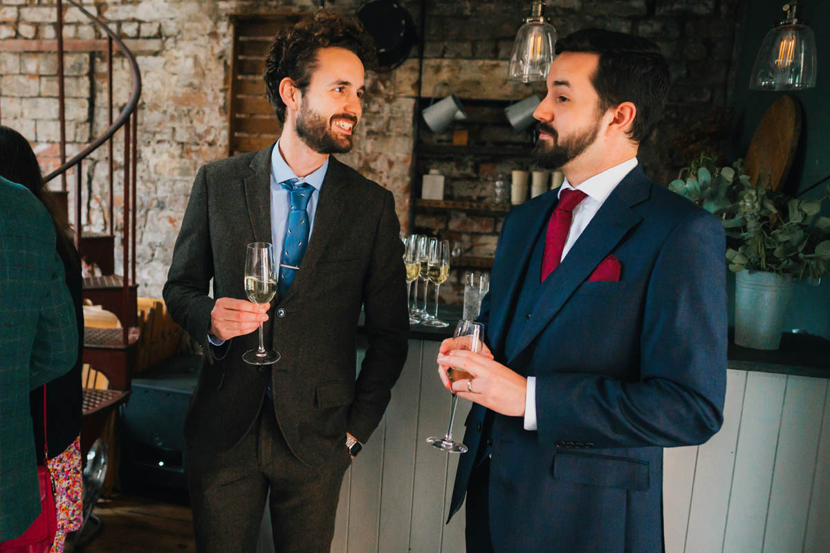 candid photography of the groom talking to wedding guests