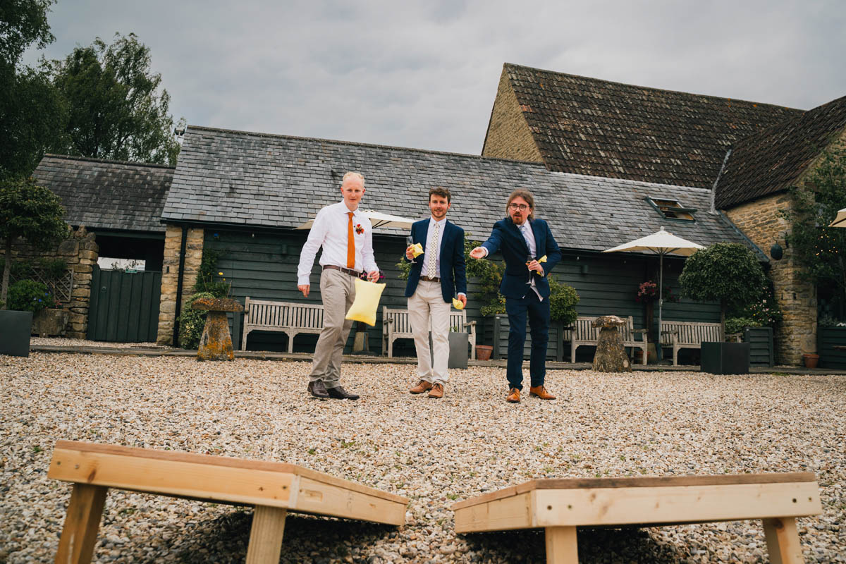 three men play games outside the wedding venue