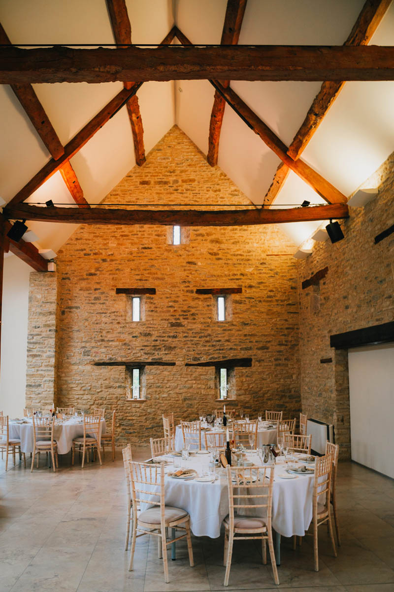 the interior of winkworth farm with tables and chairs set up ready for the wedding breakfast