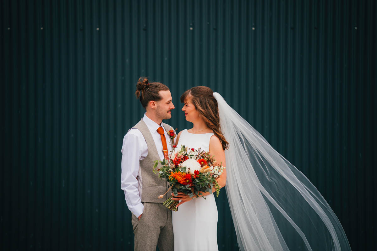 bridal portrait against a corrugated barn