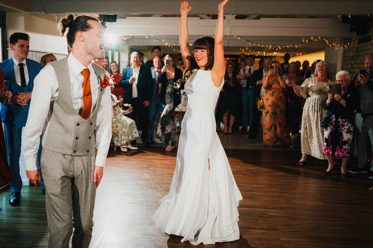 guests watch as the bride and groom dance their first dance. an off-camera flash creates a a starburst behind