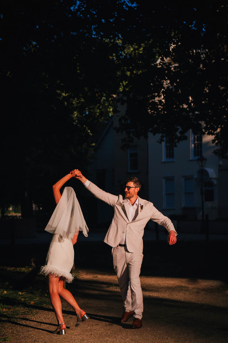 a groom swings his new wife around in a dance in Bristol's queen's square