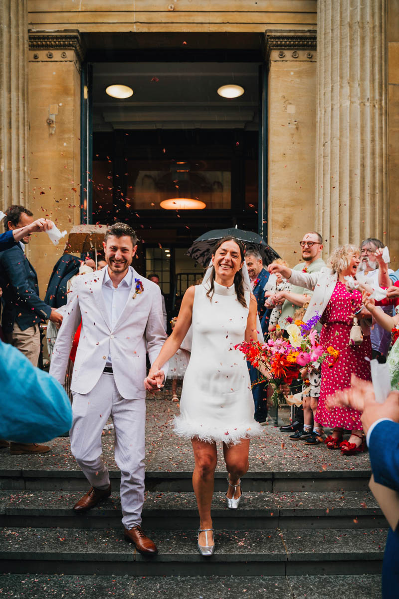 wedding guests throw confetti over the newly-married couple