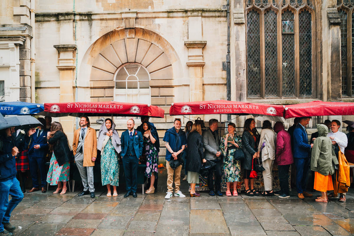 wedding guests shelter under St Nicholas Market stalls