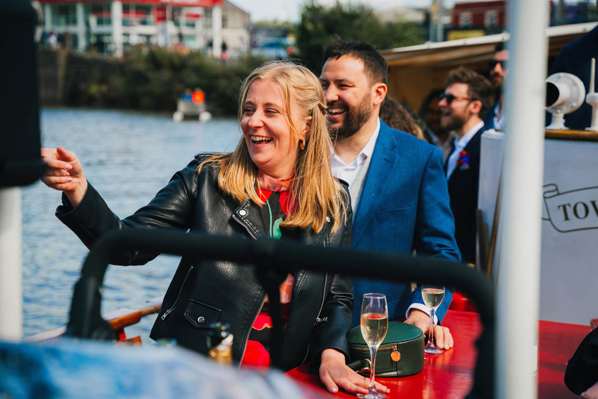 wedding guests laugh on a boat