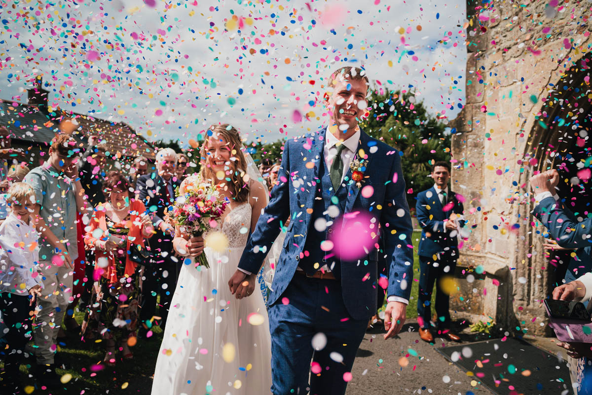 the bride and groom being showered in confetti outside the church