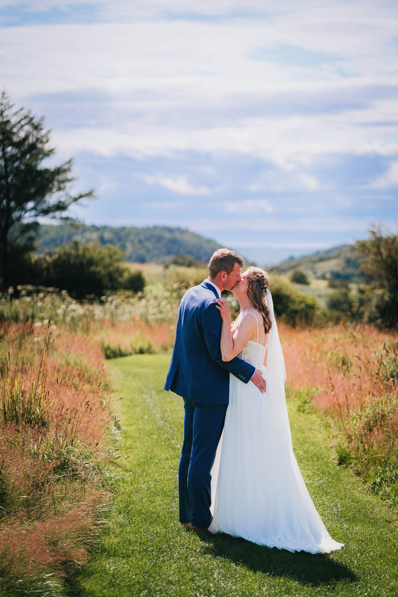 a bride and groom kiss with far reaching views behind them