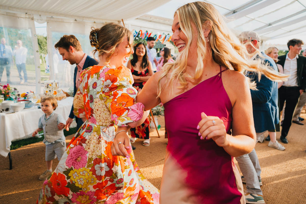 wedding guests dance the ceilidh in the marquee