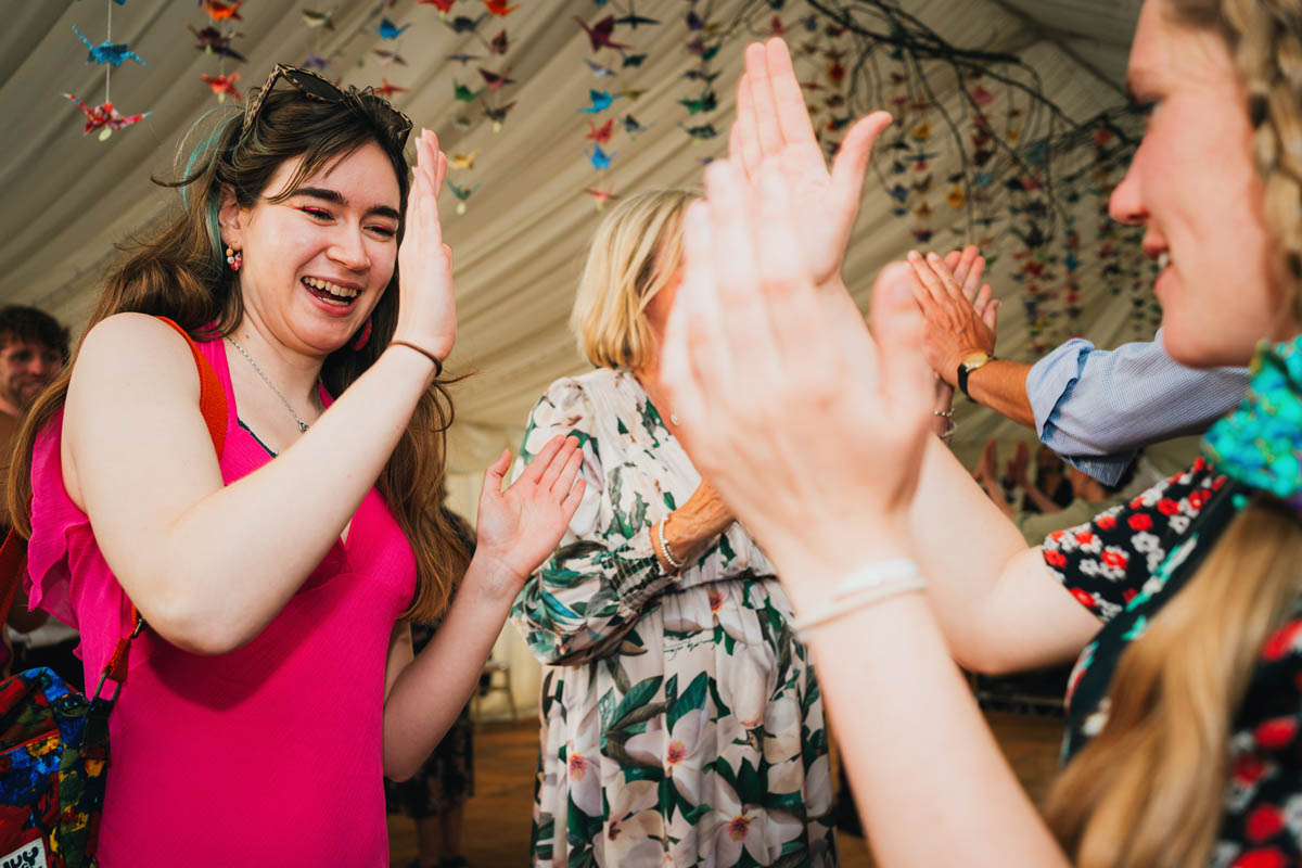 two women clap as they dance to a ceilidh