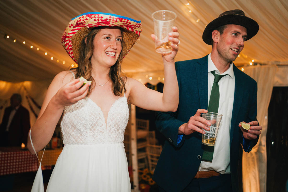 the bride and groom drinks tequila in sombreros