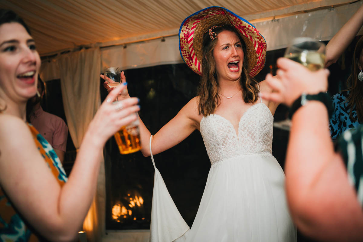 a woman wears a sombrero and wedding dress as she danced on her wedding day