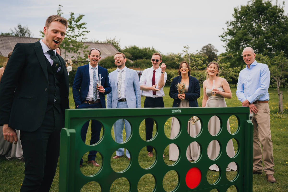 wedding guests laugh at the groom playing connect four