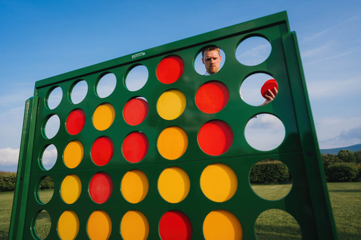 a man's head if perfectly framed by the connect four game