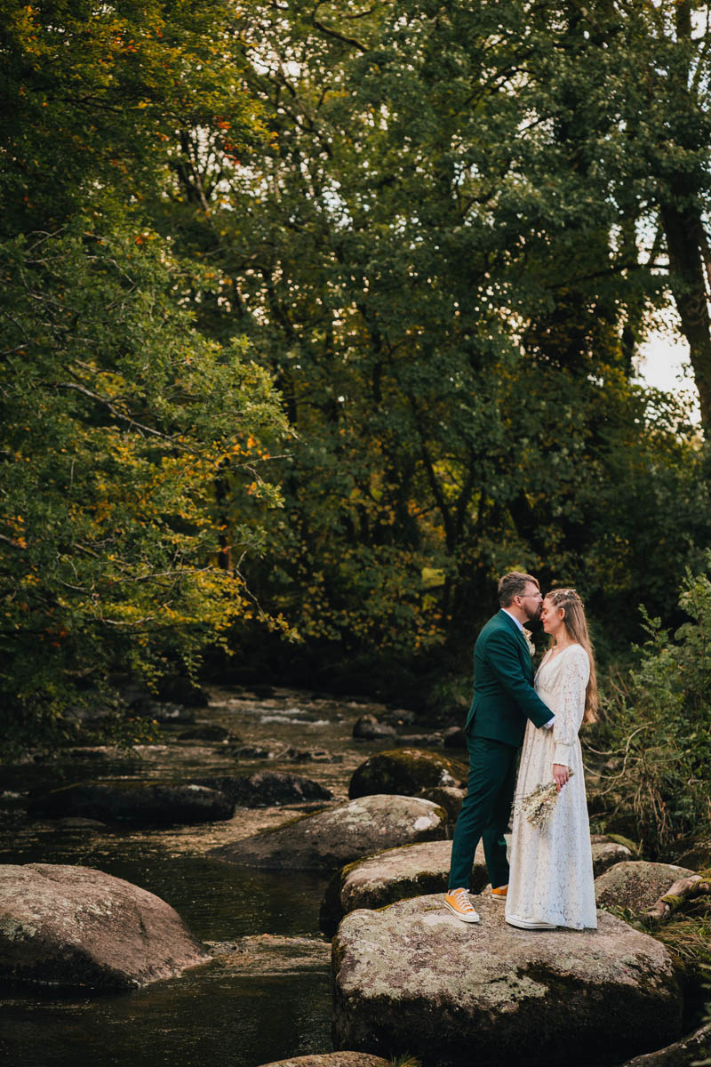 a couple kiss amongst the woods