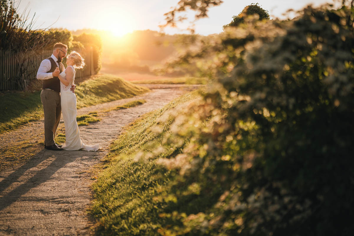 a couple hug and laugh at sunset