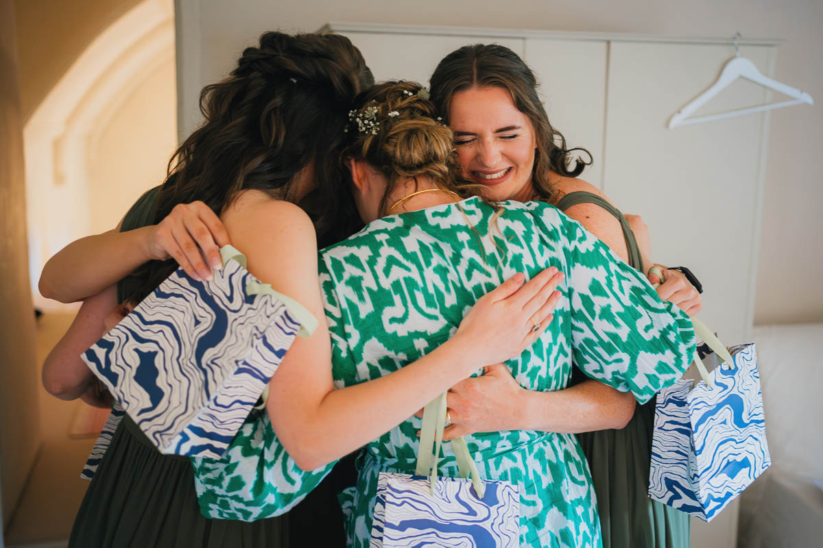 a bride hugs her bridesmaids