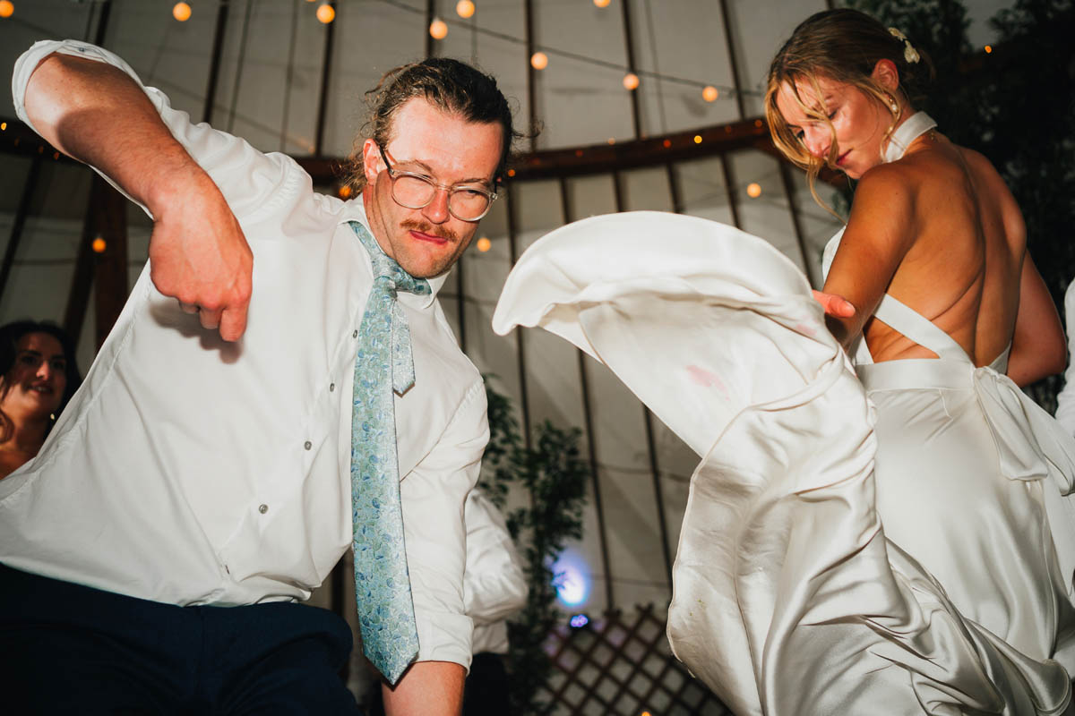 a man dances and pulls a funny face as a woman swirls her dress