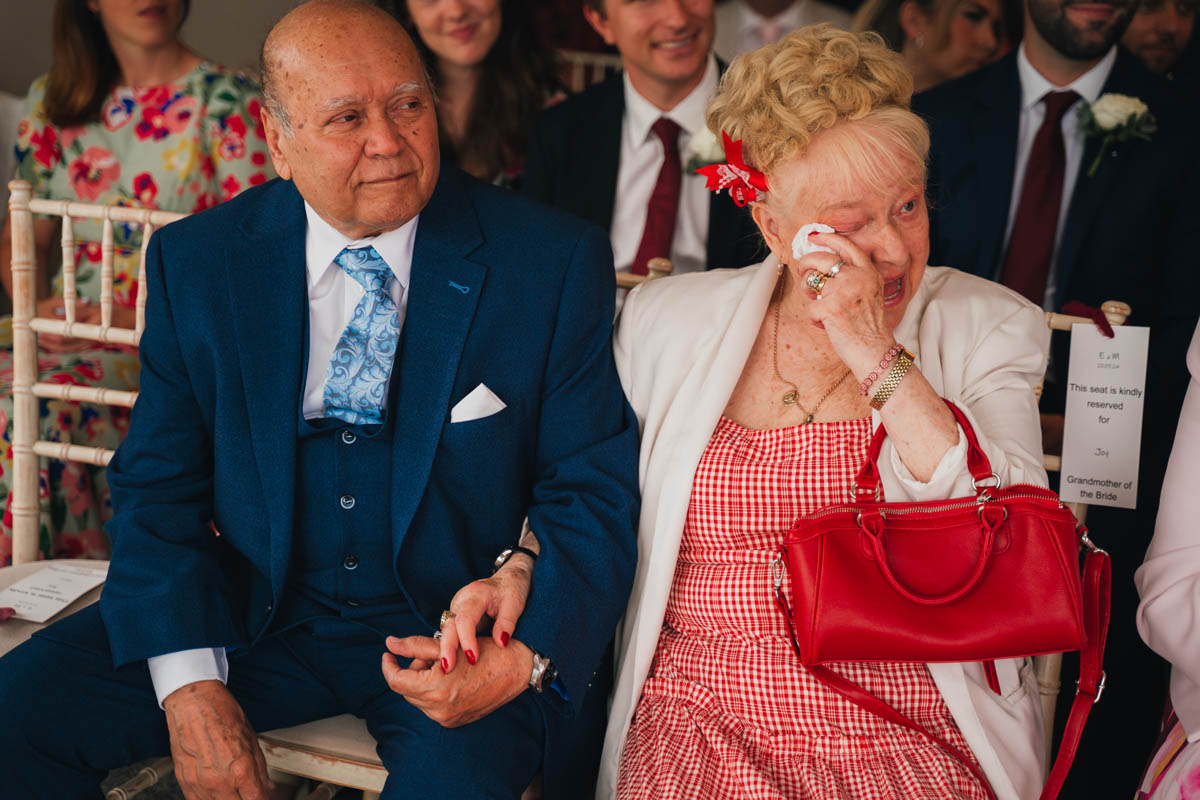 a woman wipes away a tear as she holds her partners hand