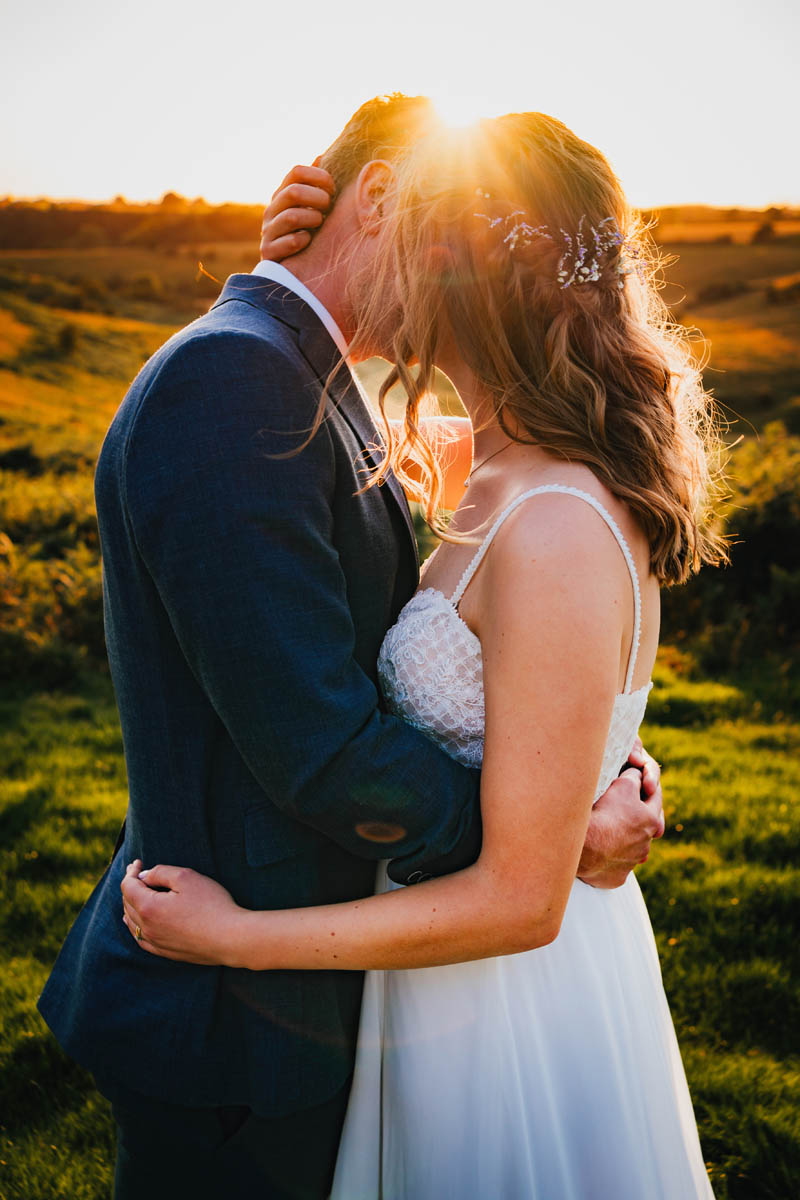 the sun glows behind a woman and man who hug