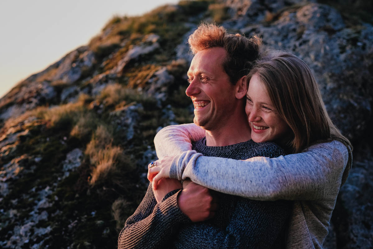 A woman hugs her fiance from behind